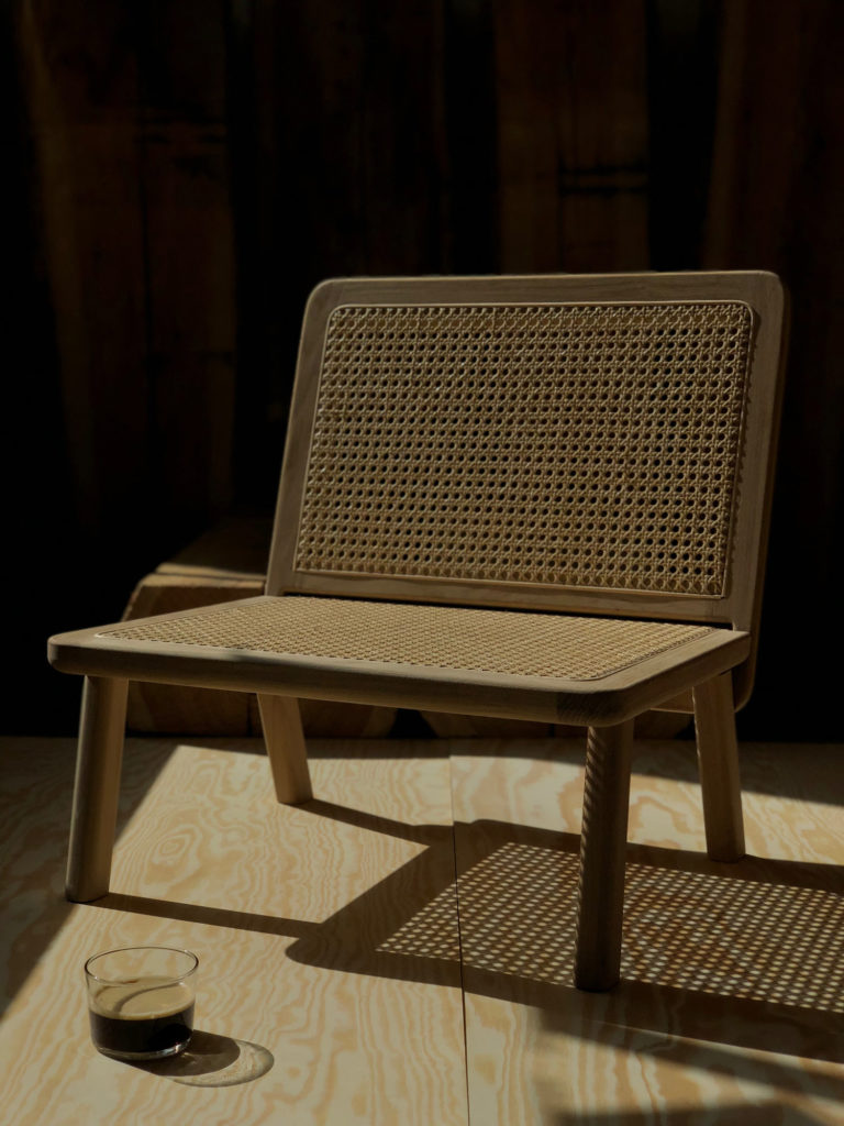 A minimalist lounge chair in oak and rattan.